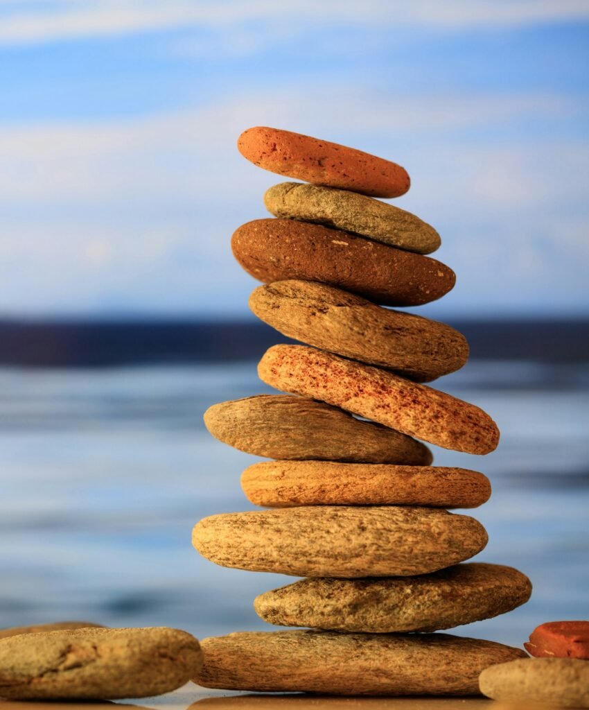 Zen stones stack on blue sky and sea background